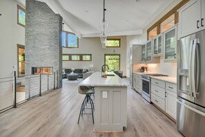 Enjoy cooking and socializing in this kitchen with a large island, bar stools, and a cozy seating area with a fireplace.