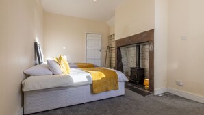 A bedroom with a bed, a fireplace, and a door.