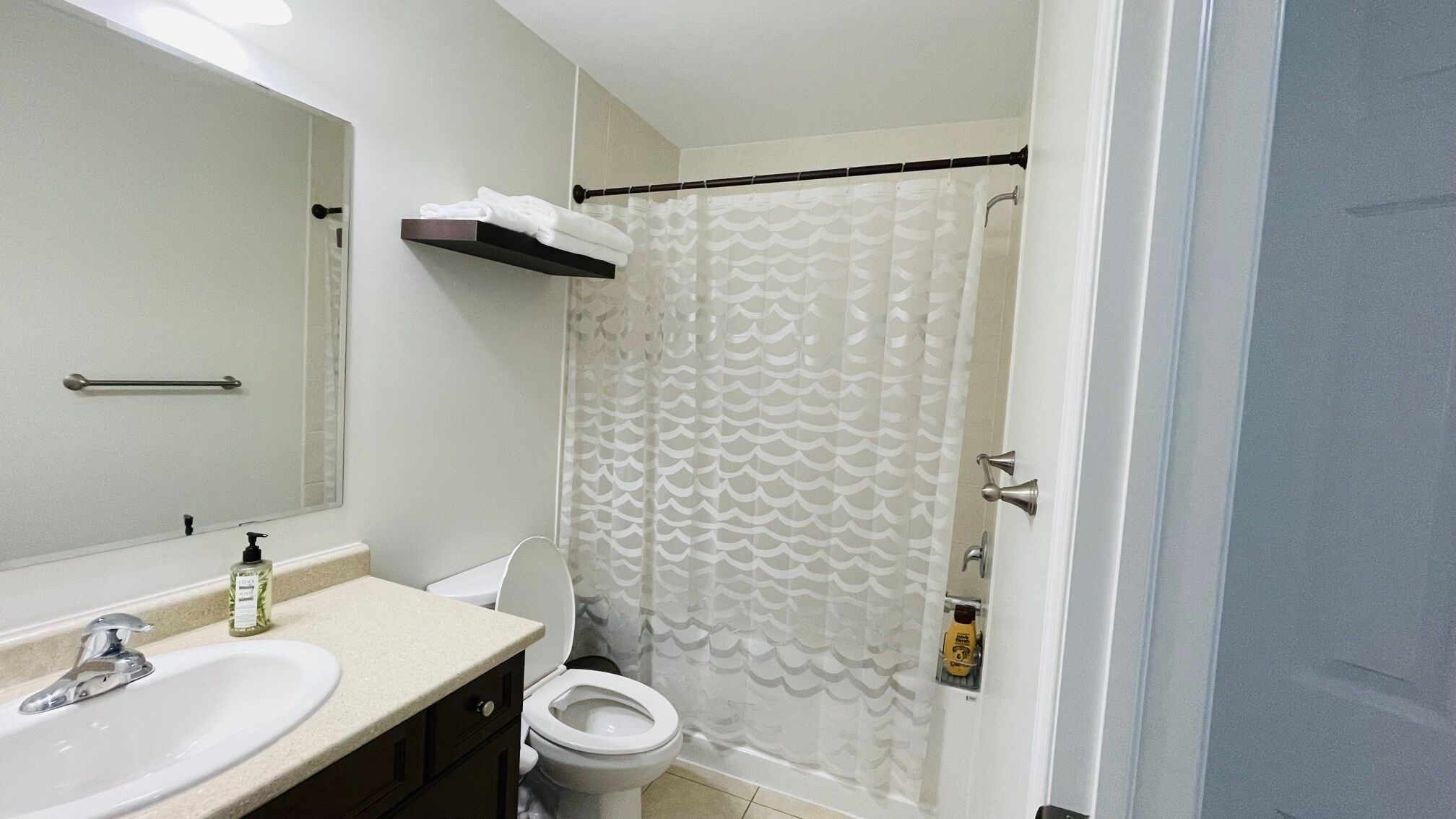 Ein Badezimmer mit Waschbecken, Toilette und Duschvorhang.