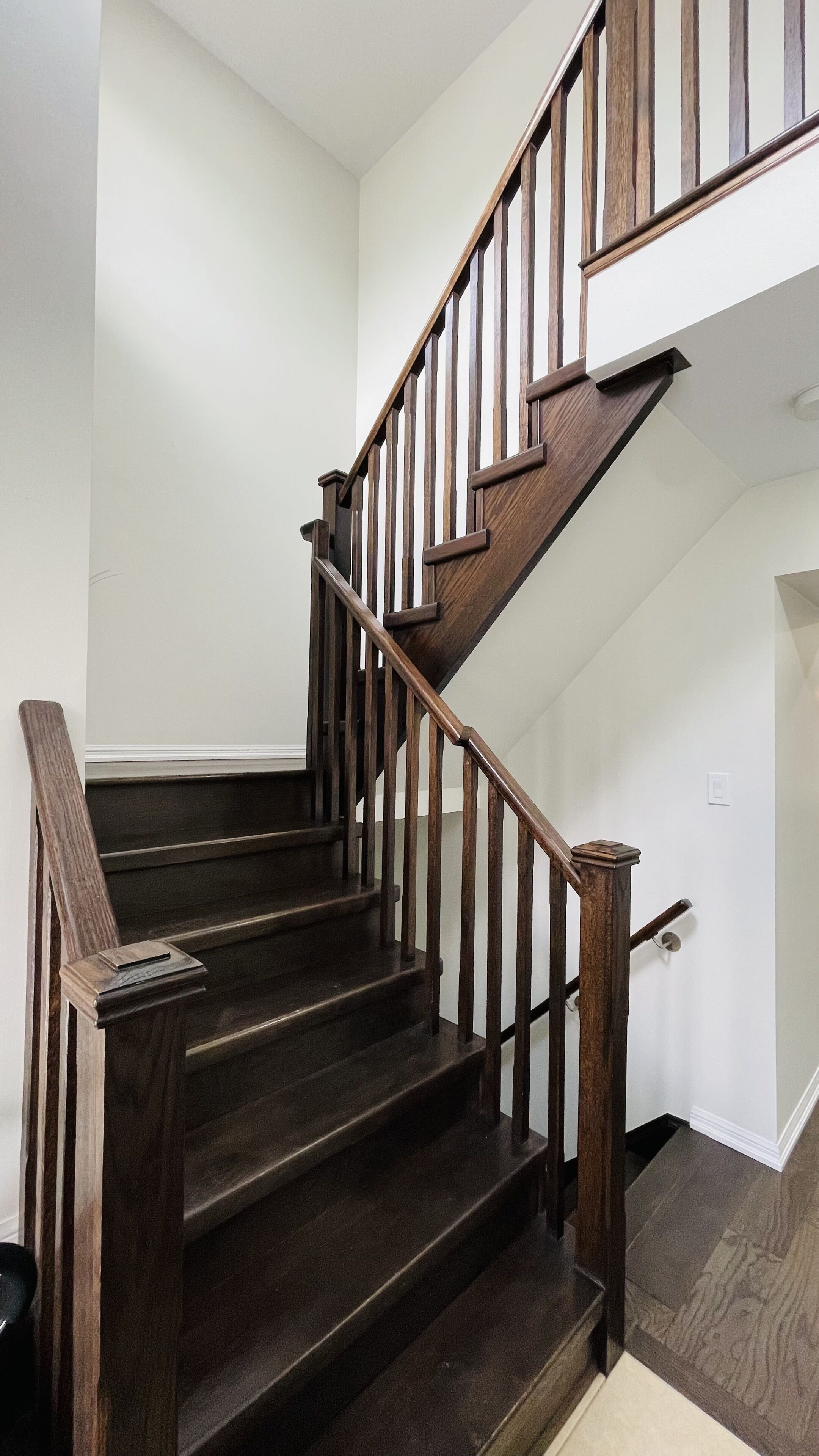 Un escalier en bois avec une rampe et un palier.