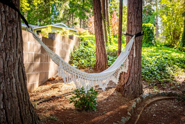 A hammock between trees in a wooded area. - The Eclipse House: Escape to the Trees (Nevada City)