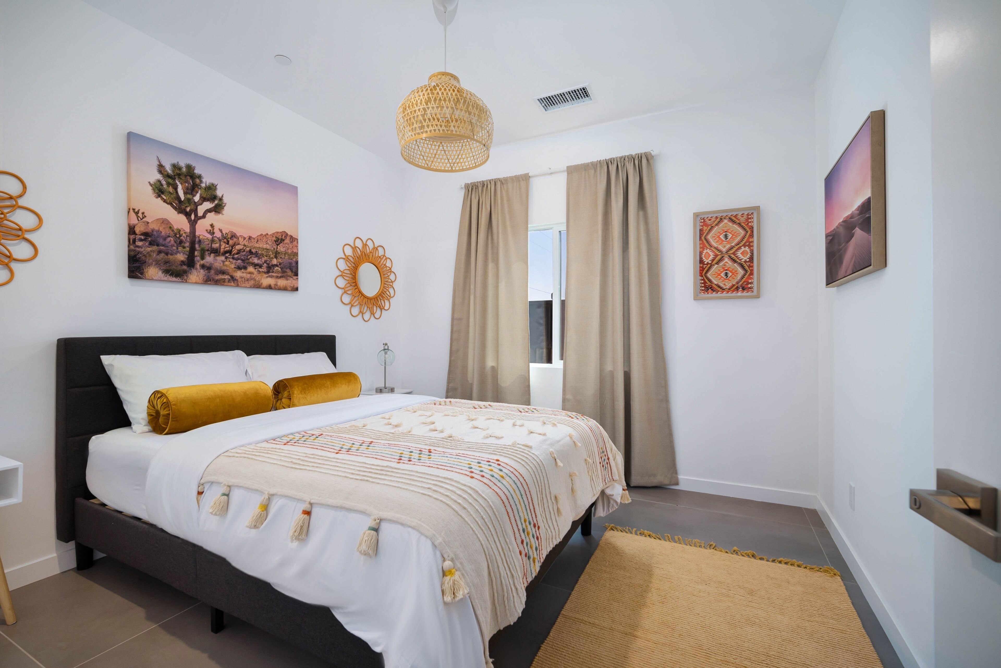 A bedroom with a bed, curtains, and wall decorations.