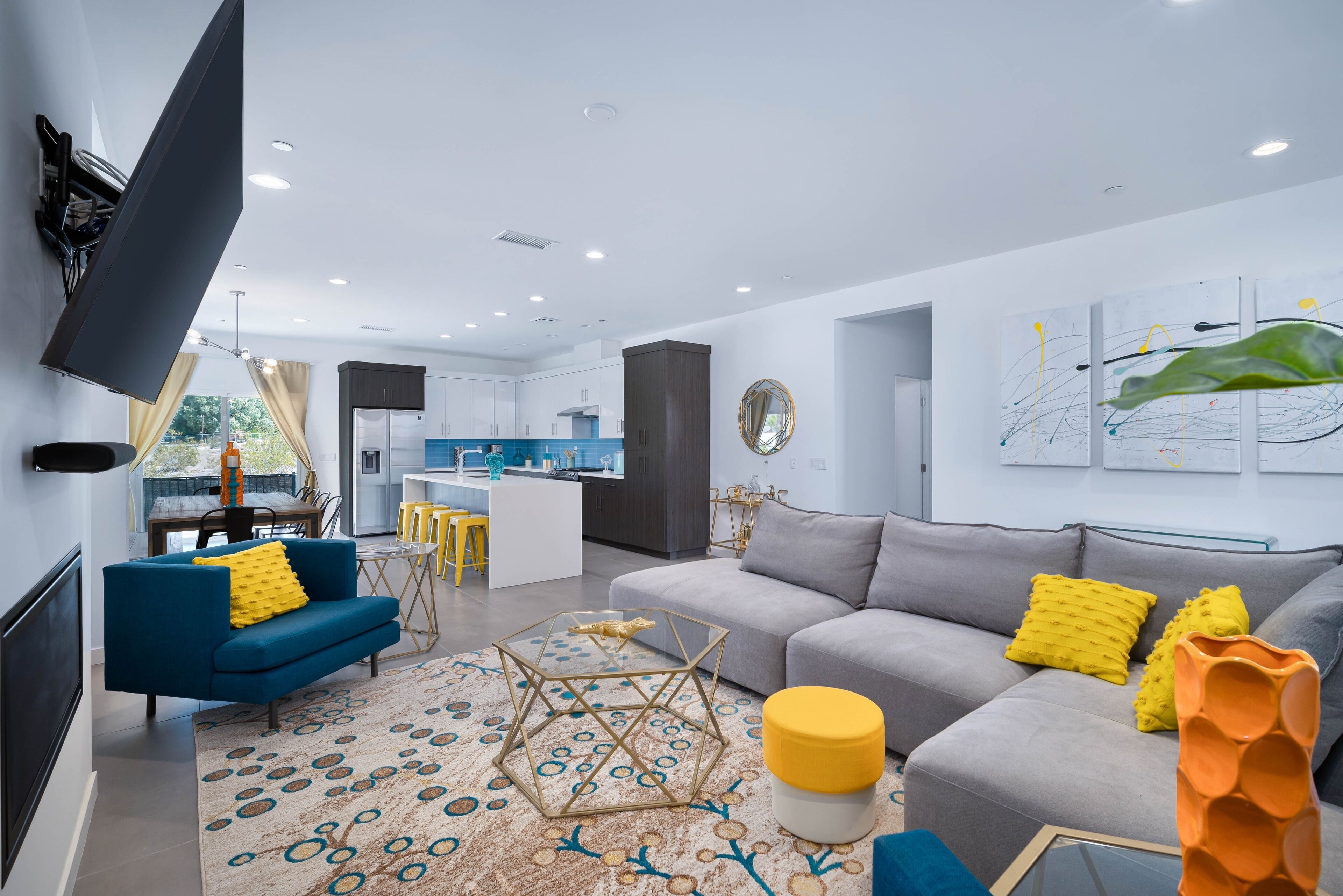 A modern living room with a sofa, coffee table, and a TV mounted on the wall.