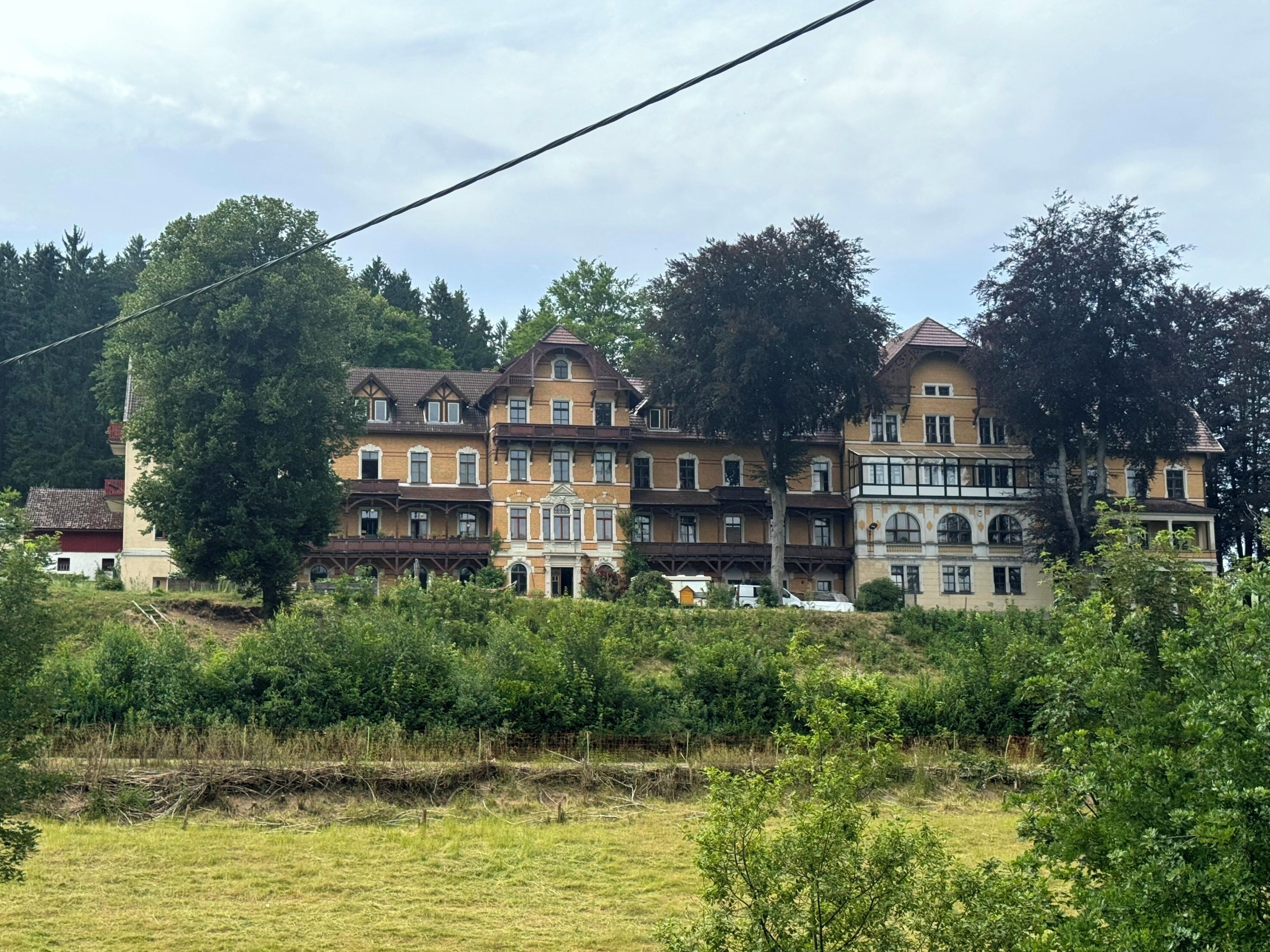 Ein mehrstöckiges Gebäude im traditionellen Baustil, mit einem Balkon im zweiten Obergeschoss.