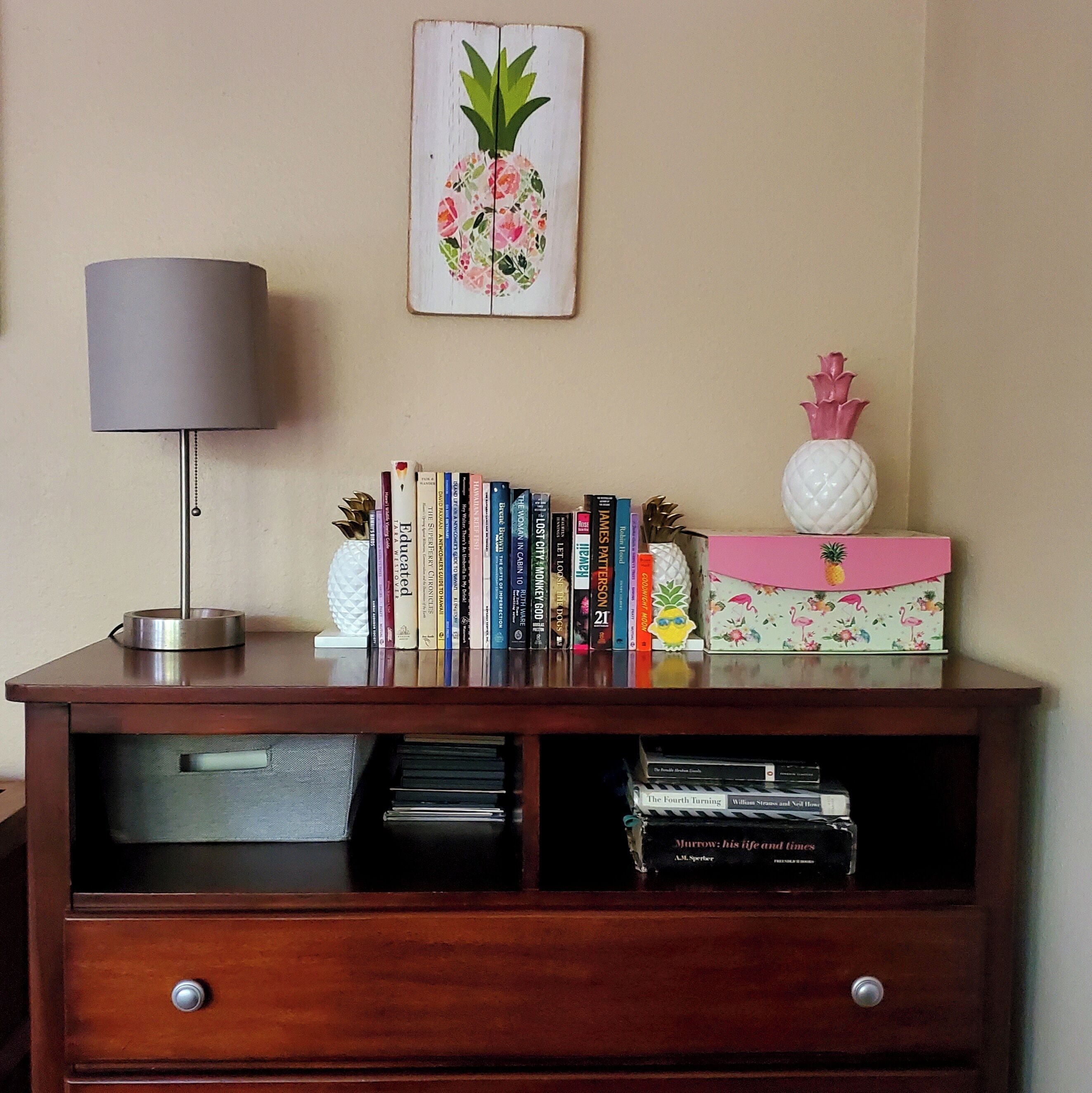 A wooden bookshelf with books, a lamp, and decorative items.