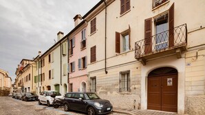 Eine Reihe historischer Gebäude mit Rundbogenfenstern und traditionellen Fensterläden.