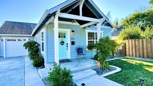 Einbungalow mit überdachter Veranda, Garage und gepflegtem Rasen.