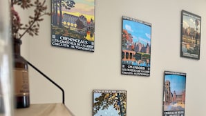 A wall with five framed posters depicting various French landmarks and locations.