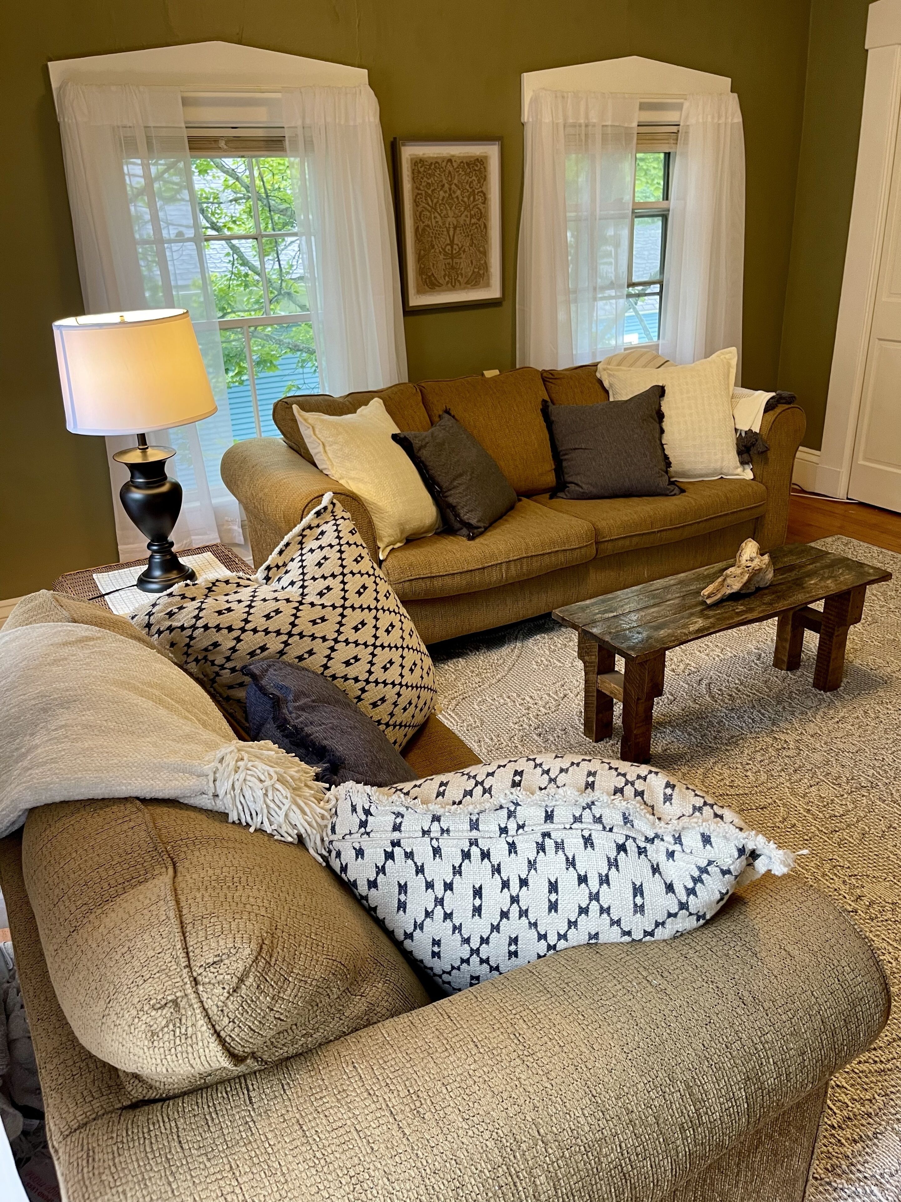 A cozy living room with a sofa, a coffee table, and a lamp.