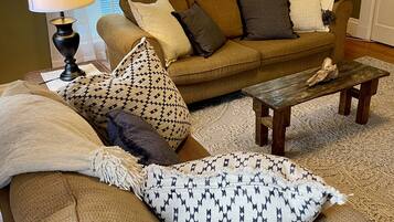 A cozy living room with a sofa, a coffee table, and a lamp.