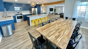 Una cocina moderna con armarios azules, una mesa de comedor de madera y taburetes amarillos.