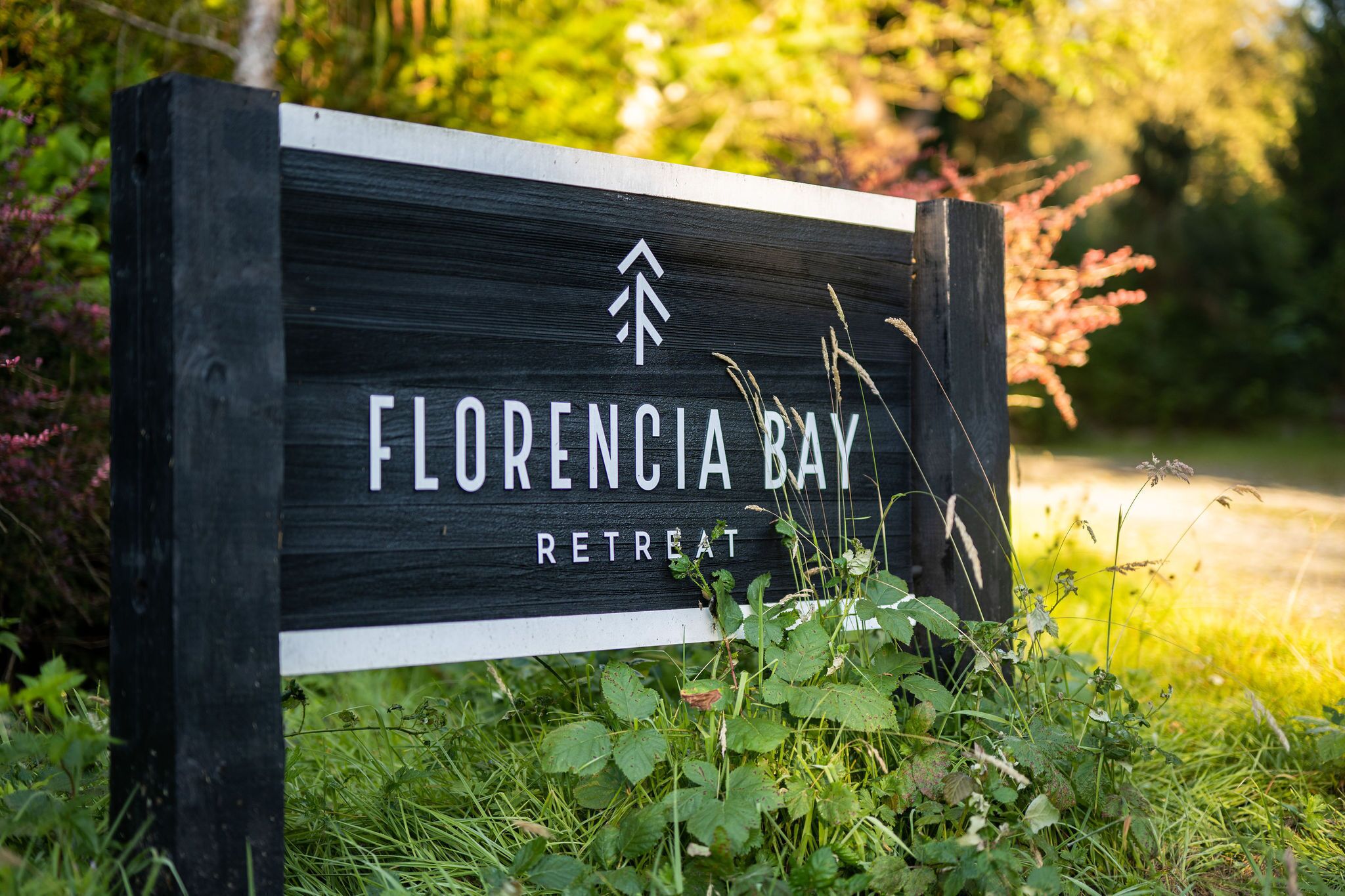 Ein Schild für das Florence Bay Retreat mit schlichtem Design und einem Logo.