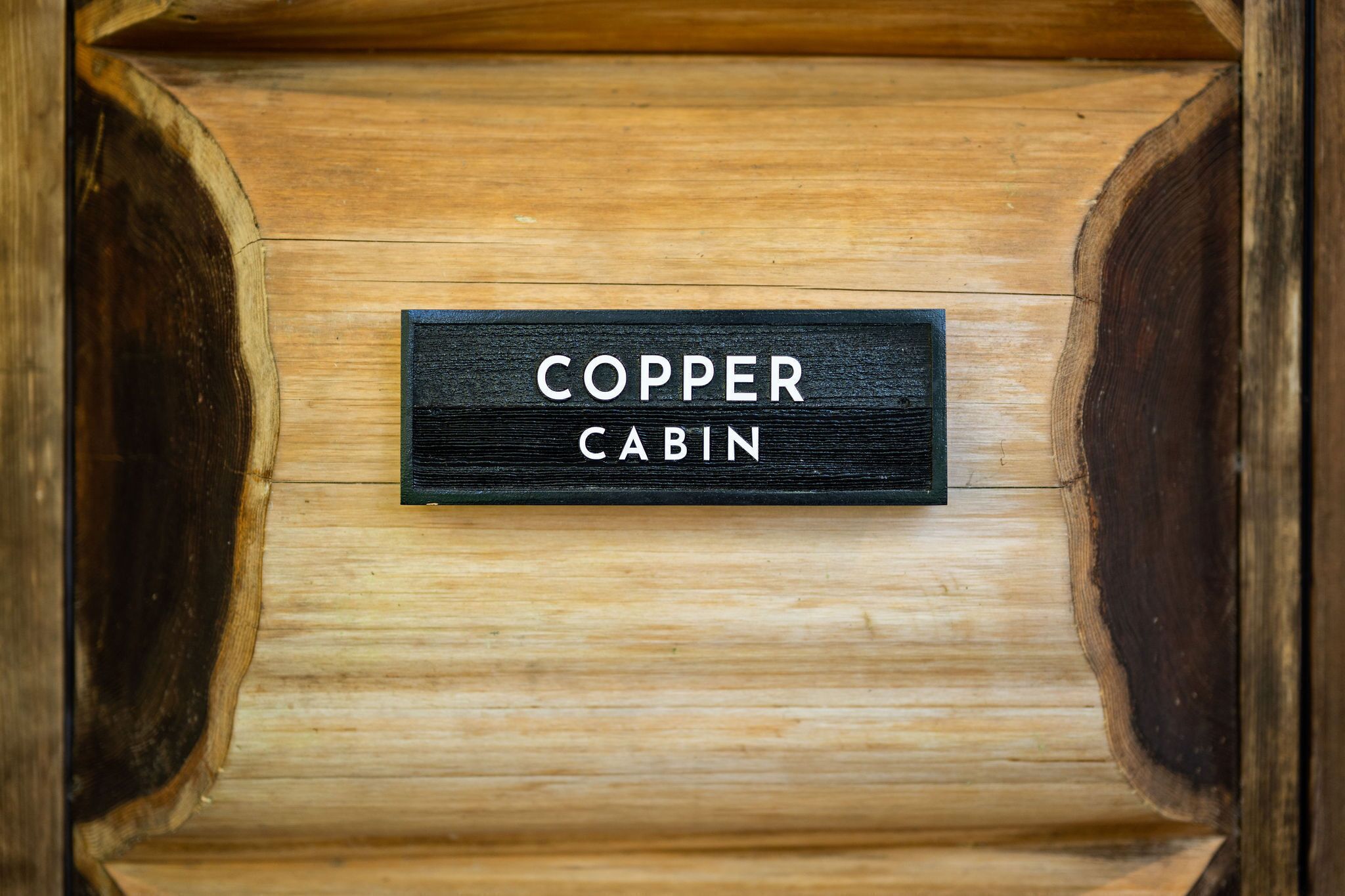 A wooden cabin with a sign that reads "COPPER CABIN."