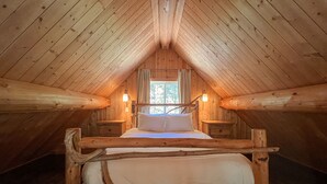 A cozy attic bedroom with a wooden bunk bed, two bedside tables, and a window with curtains. - Halfmoon Cottage I Nature Escape I Hot Tub I Pets (Ucluelet)