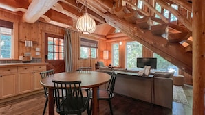 A wooden interior with a dining area, kitchen, and seating space. - Halfmoon Cottage I Nature Escape I Hot Tub I Pets (Ucluelet)