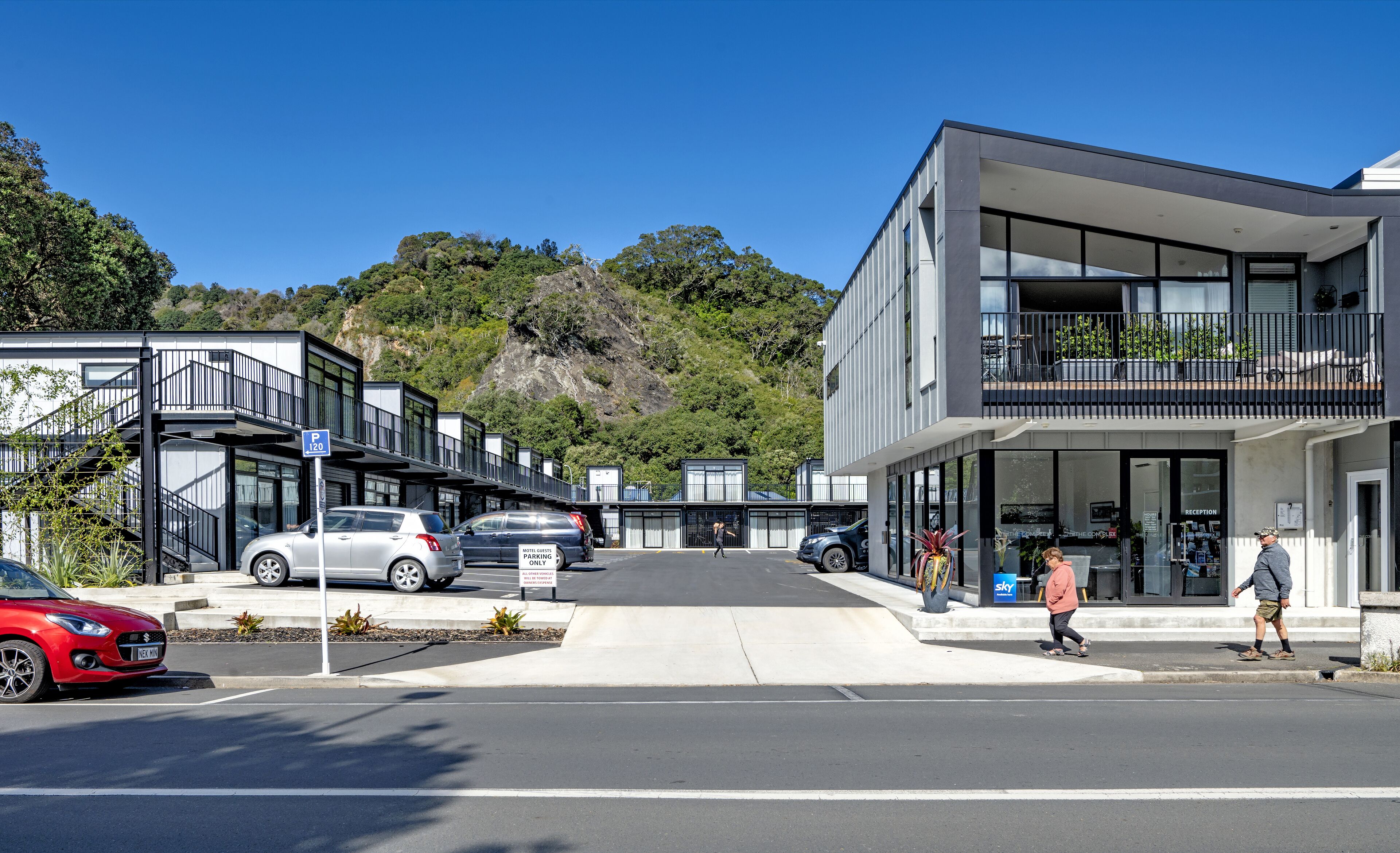 A modern hotel with a flat roof, large windows, and a reception area.