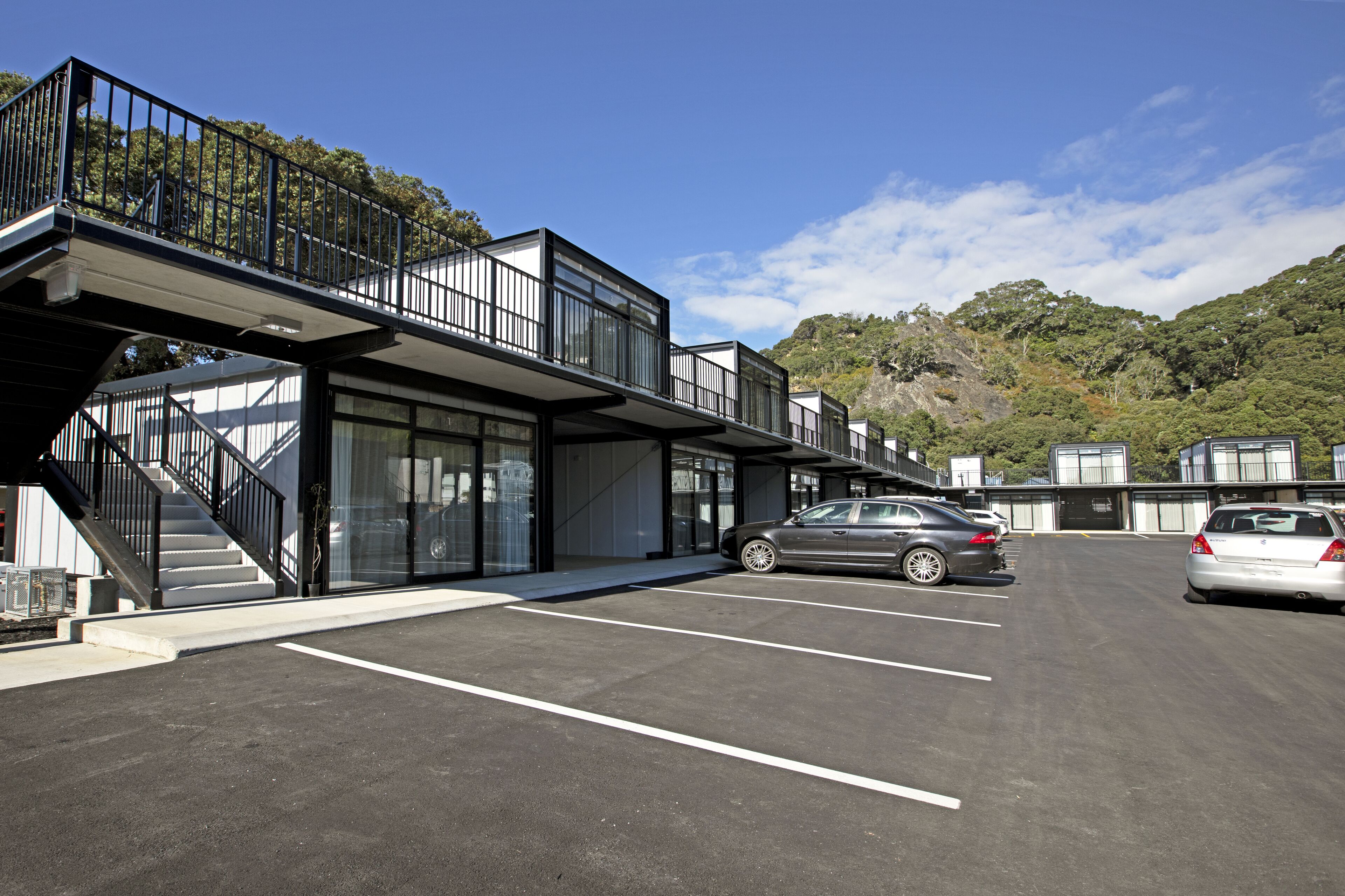 A modern building with a covered walkway and a parking lot.