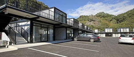 A modern building with a covered walkway and a parking lot.