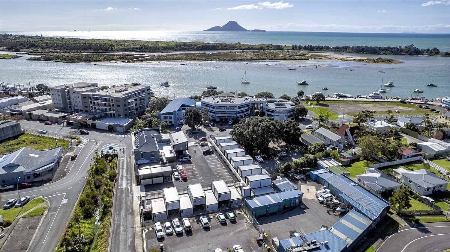 Zona industrial con almacenes, un estacionamiento y un puerto deportivo con barcos.