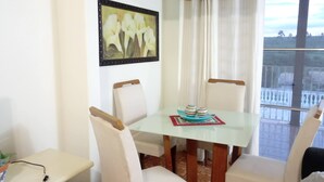 Un comedor con una mesa y sillas, un cuadro en la pared y vistas por una ventana.