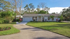 A single-story house with a front driveway, a covered porch, and a well-maintained lawn. - Cheerfull Villa..  Best Location in Naples!!!  All you need in one home. (Naples)
