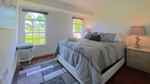 A bedroom with a bed, two windows, a nightstand, and a chair. - Cheerfull Villa..  Best Location in Naples!!!  All you need in one home. (Naples)
