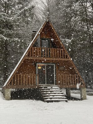 A wooden cabin with a balcony, surrounded by snow-covered trees. - Private Rustic A-Frame in the Heart of Elk Country (Benezette)