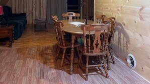 A cozy attic room with a wooden dining table and chairs, a ceiling fan, and a small window. - Private Rustic A-Frame in the Heart of Elk Country (Benezette)