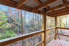 A wooden deck with a view of a forest in autumn. - Cozy Couples/Climbing Getaway in Heart of RRG! (Campton)