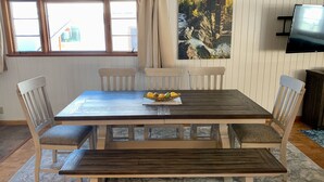 Ein Essbereich mit Holztisch, vier Stühlen und einer Obstschale.