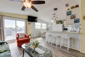 Relax in this stylish living area with a comfortable armchair, glass coffee table, and a view of the surrounding neighborhood.