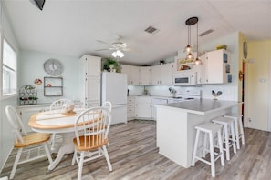 Enjoy cooking in this well-equipped kitchen with a central island, microwave, stove, and sink.
