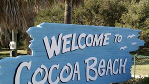 Een houten bord met de tekst 'WELCOME TO Cocoa Beach'.