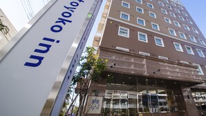 A hotel with a modern design, featuring a prominent sign and a multi-story building with numerous windows. - Toyoko Inn Tokyo Akishima-eki Minami-guchi (Akishima)