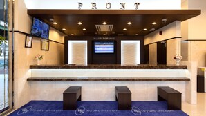 A hotel reception area with a digital display, marble counter, and reception desk. - Toyoko Inn Tokyo Akishima-eki Minami-guchi (Akishima)