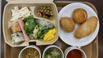 A meal tray with various dishes including rice, vegetables, and bread.