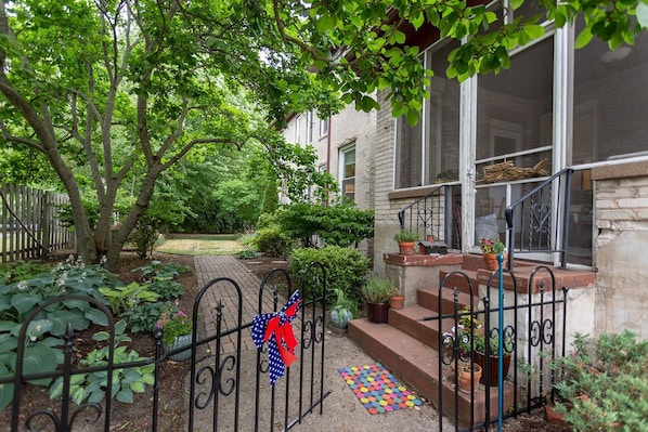 Stroll through the beautifully maintained garden to the inviting entrance, marked by a decorative metal gate.