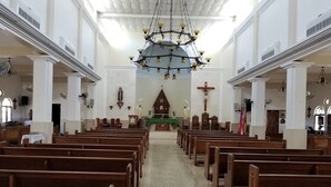 A church interior with wooden pews, a central altar, and a chandelier. - Cozy Apartment in the Heart of Rincon (Rincon)