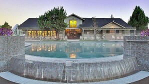 Un hotel con piscina, una cascada y un jardín bien cuidado.