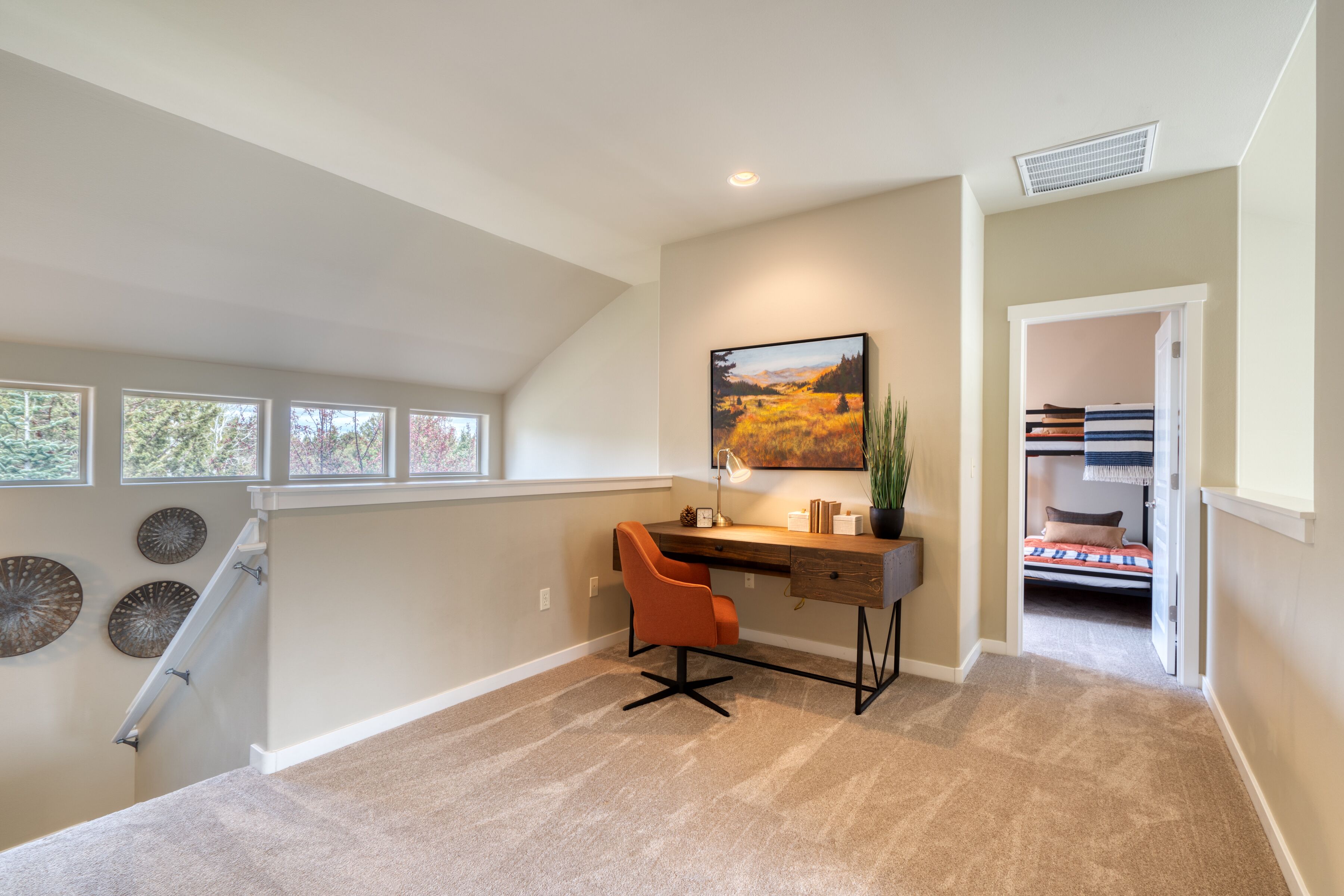 Une chambre moderne avec un bureau, un lit et un escalier.