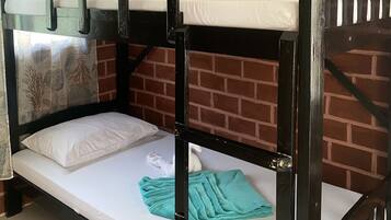 A bunk bed room with a brick wall background, a window with a curtain, and a tiled floor.