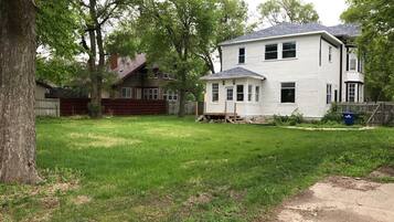 A two-story house with a front yard and a wooden fence.