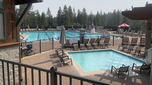 A pool area with multiple pools, lounge chairs, umbrellas, and a lifeguard tower. - Fully updated Truckee cabin with plenty of beds (Truckee)