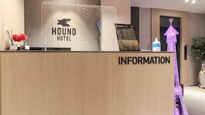 A reception desk with a sign reading "HOUND HOTEL" and an "INFORMATION" sign below it. - Hound Hotel Sasang (Busan)