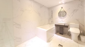 A modern bathroom with a bathtub, a toilet, and a sink. - Hound Hotel Sasang (Busan)