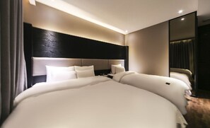 A modern hotel room with a large bed, a dark headboard, and a mirror on one wall. - Frenchcode Hotel (Busan)