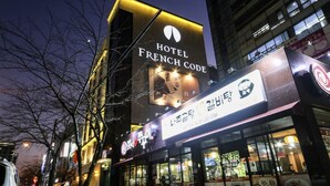 Ein Gebäude mit einem Schild für "Hotel French Code" und ein Restaurant mit koreanischer Beschriftung.