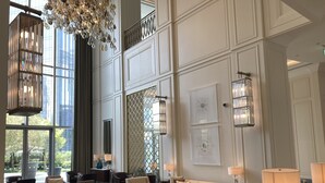 A spacious lobby with high ceilings, large windows, and modern furnishings including sofas, armchairs, and tables. - Ultimate Luxury Address Boulevard Dubai - 3 Bedrooms (Dubai)