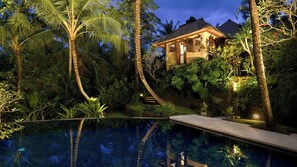 A house with a pool surrounded by tropical vegetation.