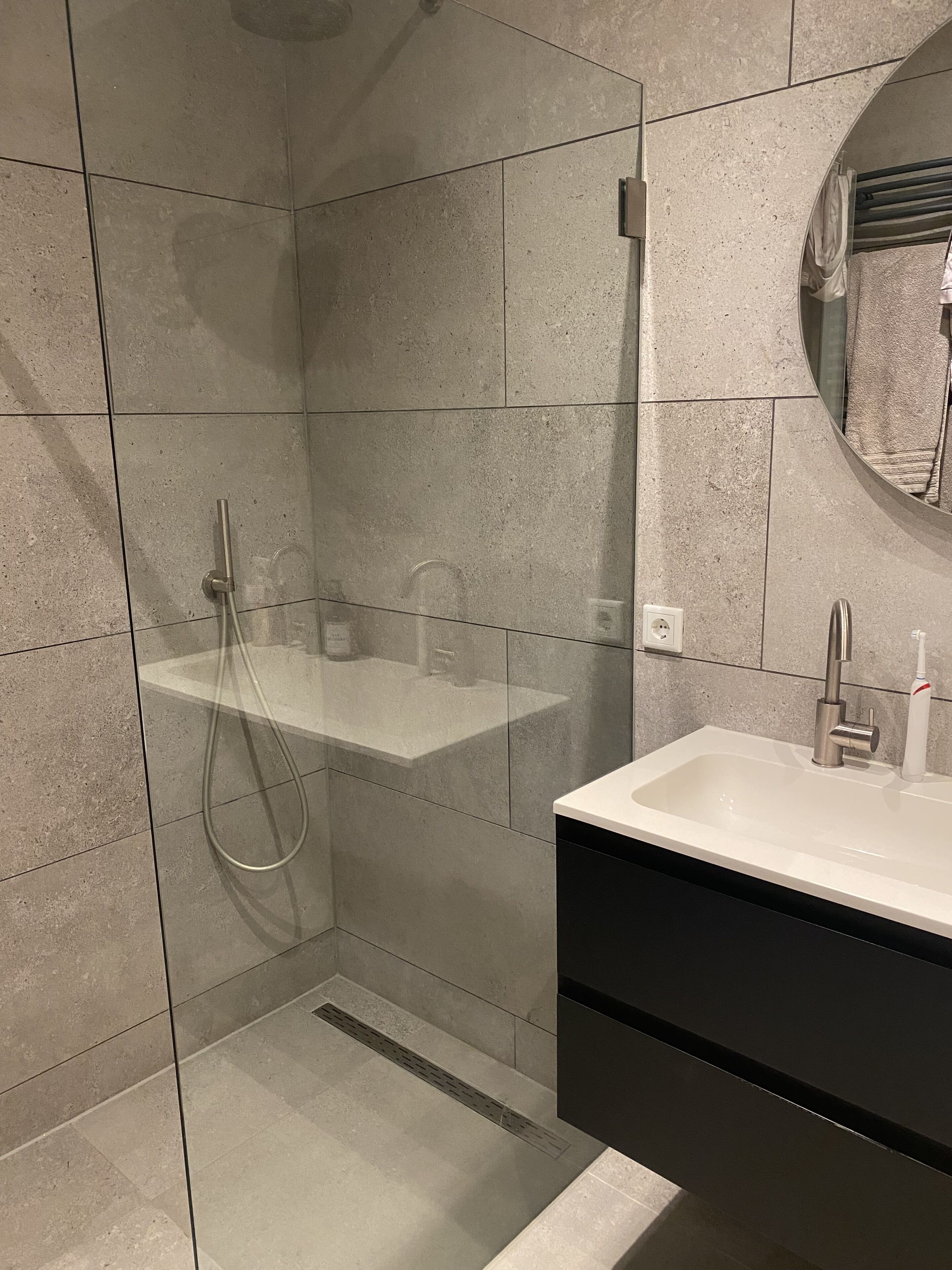 Een bad/douchecombinatie, een haardroger, handdoeken, toiletpapier